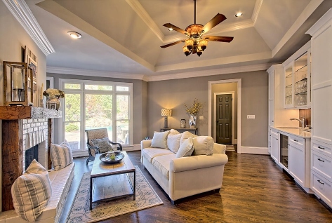 Cozy living room with white sofa, brick fireplace, ceiling fan, and large windows in Duluth, GA