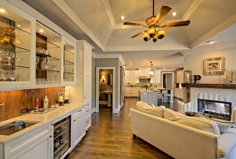 Elegant living room with white sofa, glass cabinets, and open kitchen in Duluth, GA