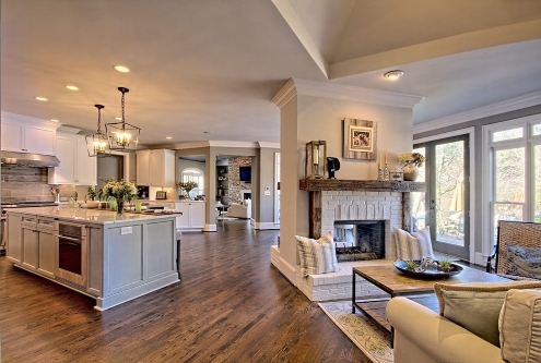 Modern open kitchen with island and cozy living area featuring a white brick fireplace in Duluth, GA