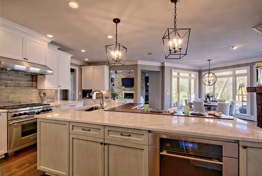 New age kitchen with marble island, pendant lights, cabinets, and dining area view in Duluth, GA