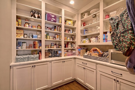Pantry with cabinets and shelves stocked with canned goods, snacks, and kitchen items in Duluth, GA