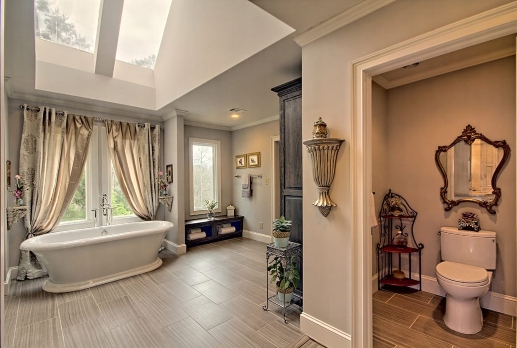 Bathroom renovated with a freestanding tub, windows, and an adjacent toilet room in Atlanta, GA