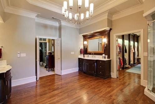 Large bathroom with chandelier, dark wood vanity, and adjoining walk‑in closet in Atlanta, GA