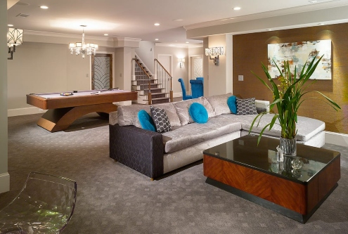 Elegant basement lounge remodeled with sofa, pool table, and warm lighting accents in Atlanta, GA