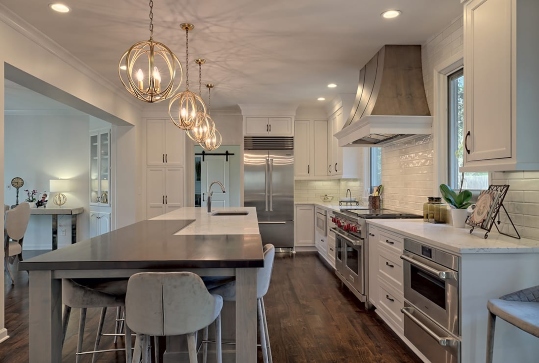 kitchen remodeled with long island, pendant lights, and cabinetry in Atlanta, GA